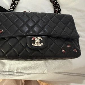 Chanel limited edition black lambskin classic bag with “ladybug” hardware.